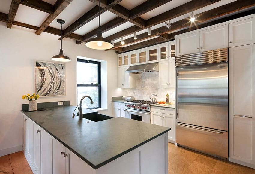 Contemporary kitchen with peninsula soapstone counters, exposed beams and white shaker cabinets