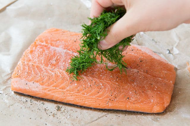 Adding fresh dill to salmon fillet