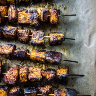 skewers of grilled eggplant on a baking sheet