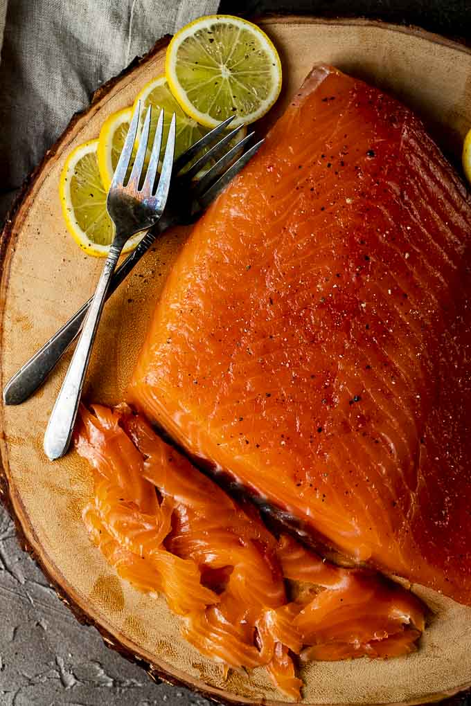 sliced cured salmon on a platter with lemon slices